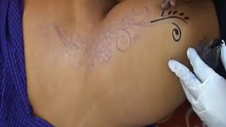 Indian woman exposes shaved XXX pussy while master applies tattoo