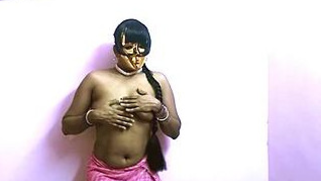 Masked Desi belle covers XXX assets while posing naked near wall