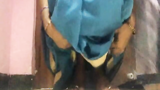 Amateur porn video where Desi MILF lifts blue dress to play with pussy
