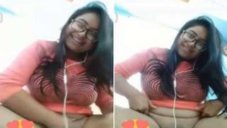 Smiling Indian with glasses listens to music and undresses at once